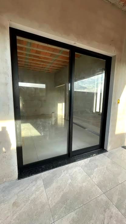 Porta de correr em alumínio preto da Linha Suprema, projeto real em obra executado pela HB Vidros