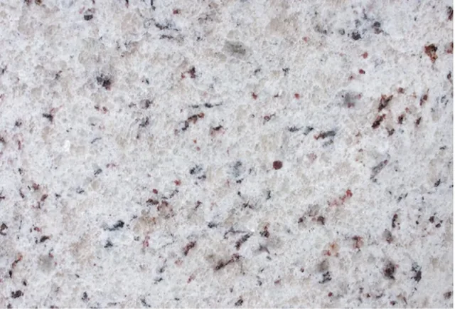 Amostra de granito Branco Marfim, fundo claro com pintas vinho e cinza