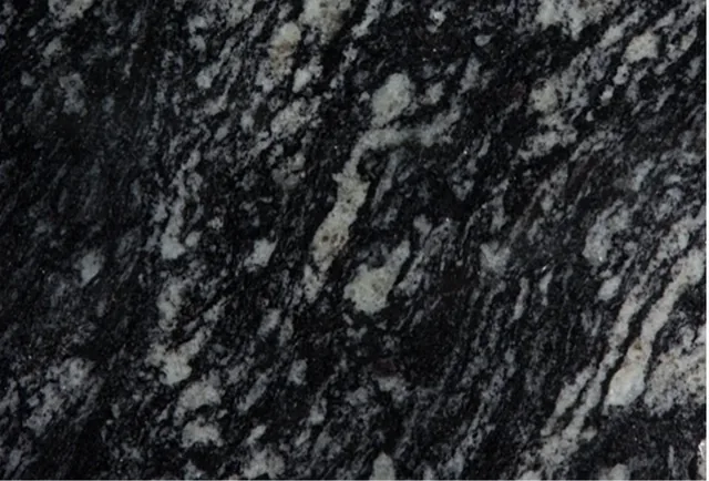 Amostra de granito Preto Indiano, fundo preto com manchas claras